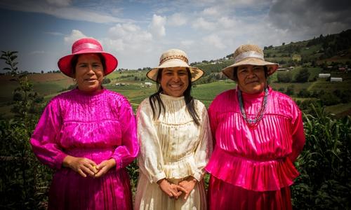 Mujeres indígenas mazahuas del Estado de México portando su traje tradicional en color rosa y blanco.