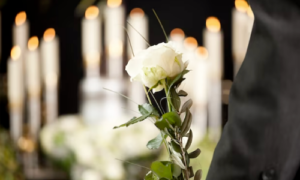 imagen esquela flor blanca y velas prendidas