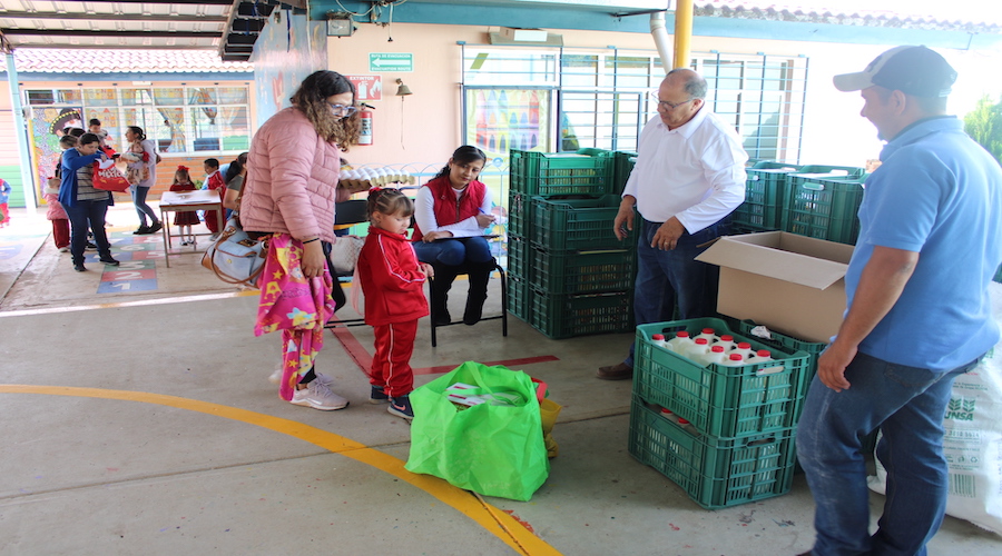 Madre e hija recibiendo despensa repleta de alimentos saludables