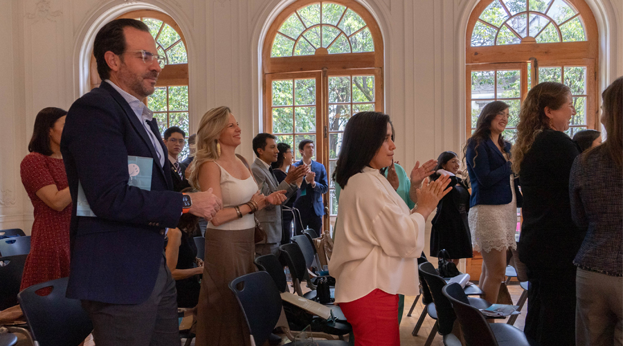 Asistentes a la ceremonia por el 20 aniversario de Fundación EBC de pie, aplaudiendo, se observa a Ivonne Madrid, directora de Fundación Alsea. También se observa a Patricia Larios, directora de Fundación ProEmpleo así como algunos becarios y exbecarios de Fundación EBC